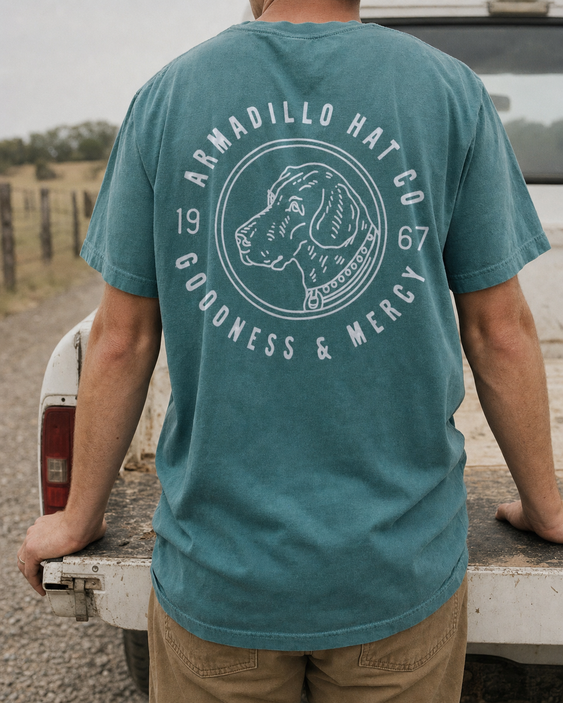 Bird Dog Tee back print in Blue Spruce at a truck tailgate